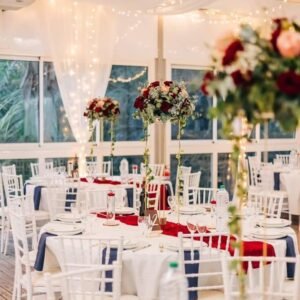 Photo d'un mariage à La Réunion – Centre de table en hauteur – Décoration florale, Chaises chiavari blanches, Guirlandes lumineuses